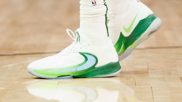 View of Giannis Antetokounmpo's white and green Nike shoes.